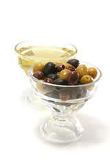 olive oil with green, black and brown olives inside bowls