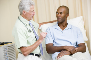 Obraz premium Doctor giving man checkup in exam room