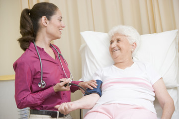 Doctor checking woman's blood pressure