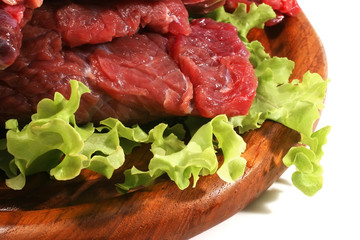 red raw beef meat and salad over white