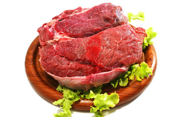 raw beef meat and salad over white on plate