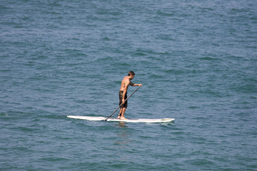 homme entrain de faire du stand up paddle