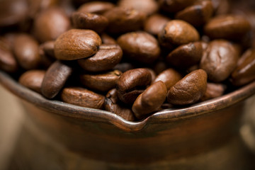 Cezve with freshly roasted coffee beans on sackcloth