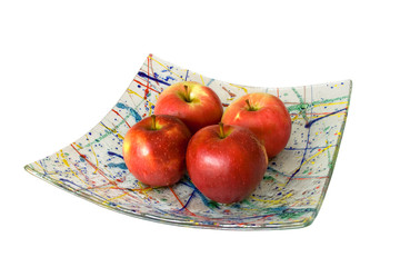 Four apples on the glass plate