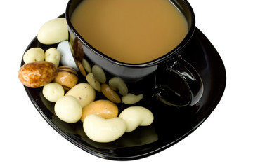 black coffee cup with milk and candies