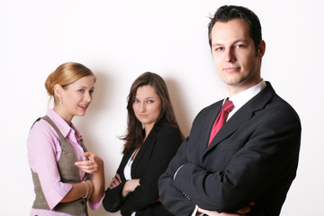 successful business man in front of two business women
