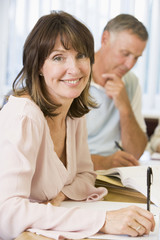 Fototapeta premium Middle aged woman studying with other adult students