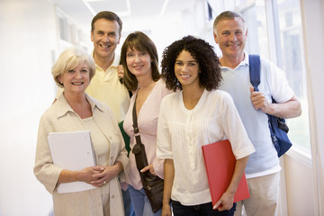 A group of adult students with backpacks standing in a campus co