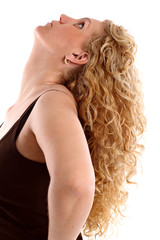 Fototapeta premium Young woman with long blonde curly hair looking up, on white.