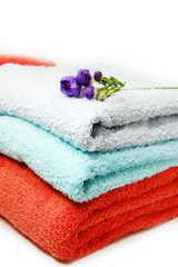 Fototapeta na wymiar towels in pile and violet flower