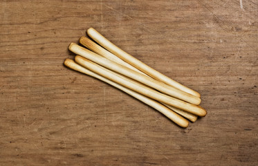 Bunch oj Bread sticks on a wooden table.