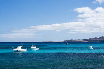Fototapeta na wymiar small white fisher boats at Lanzarote coast