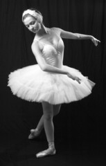 The girl in a ballet suit on a black background