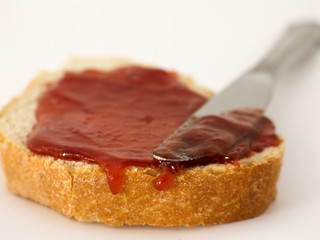 Slice of bread with jam spread and knife