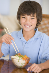 Young boy eating chinese food smiling