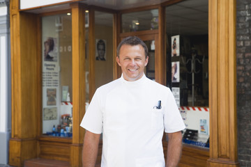 Barber standing outside shop. - Powered by Adobe