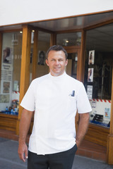 Barber standing outside shop.