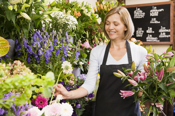 Femme travaillant au magasin de fleurs souriant