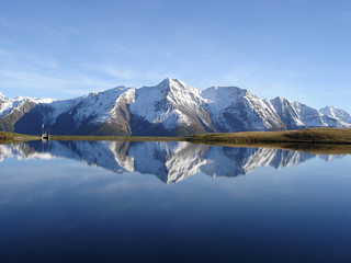 Reflection in the water of the quiet Bettmersee Lake in Valais