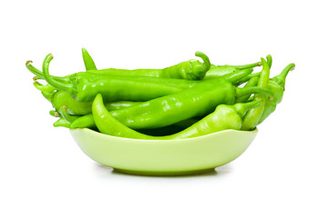 Green peppers in the plate isolated on white