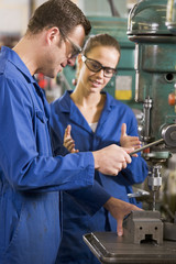 Two machinists working on machine