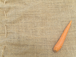 Single carrot at the brown linen