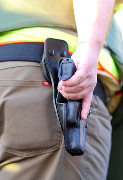 Polizist mit Hand an der Waffe