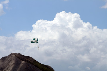 Vliegende parachute op achtergrond met lucht en bergen