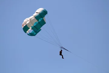 Papier Peint photo Sports aériens Parachute volant sur fond de ciel bleu