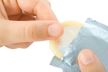 Hands umwrapping a condom isolated on white background.