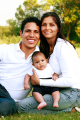 Young Parents Portrait Holding Baby in the Park
