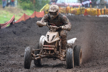 Quad bike racing in dirt and mud