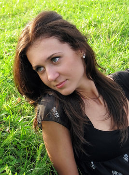 Portrait of young beautiful girl on grass background.