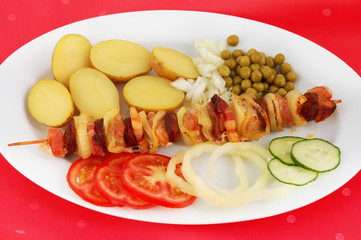 Spit with side dish on red tablecloth