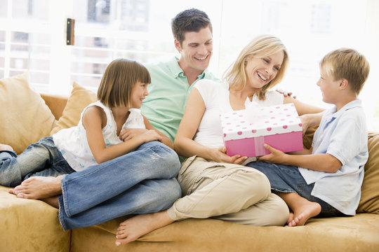 Family In Living Room With Mother Receiving Gift And Smiling