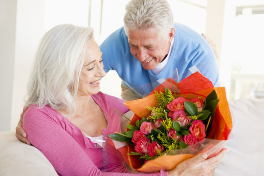 Husband Giving Wife Flowers And Smiling