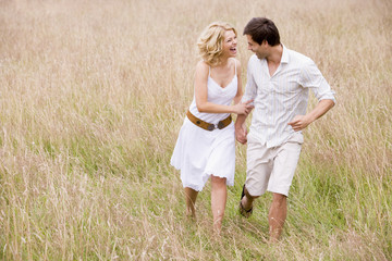 Fototapeta na wymiar Couple walking outdoors holding hands smiling