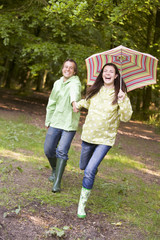 Obraz premium Couple outdoors running with umbrella smiling