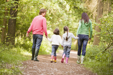 Fototapeta premium Family walking on path holding hands