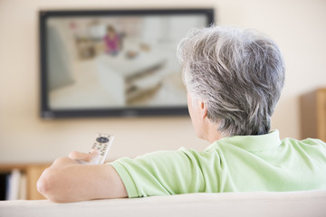 Man watching television using remote control