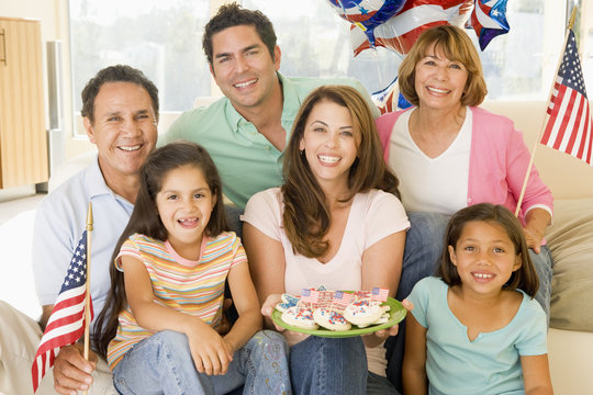 Family In Living Room On Fourth Of July With Flags And Cookies S