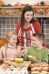 Mother and two children at Halloween making treats and smiling