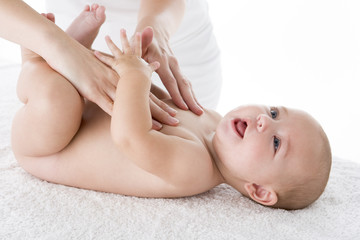 Fototapeta na wymiar Mother massaging baby