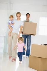 Fototapeta na wymiar Family with box moving into new home smiling