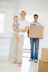 Fototapeta na wymiar Family with box moving into new home smiling