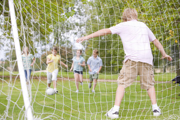 Five young friends playing soccer