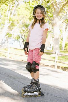 Young girl outdoors on inline skates smiling