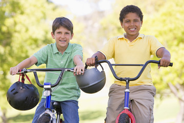 Obraz premium Two young boys on bicycles outdoors smiling