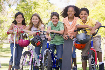 Five young friends with bicycles scooters and skateboard outdoor © Monkey Business