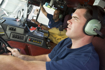 A firefighter driving a fire engine
